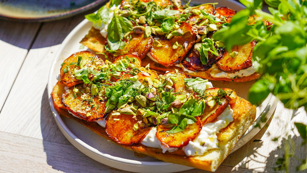 Geroosterd zuurdesembrood met gebakken perzik, burrata, honing & pistachenoten