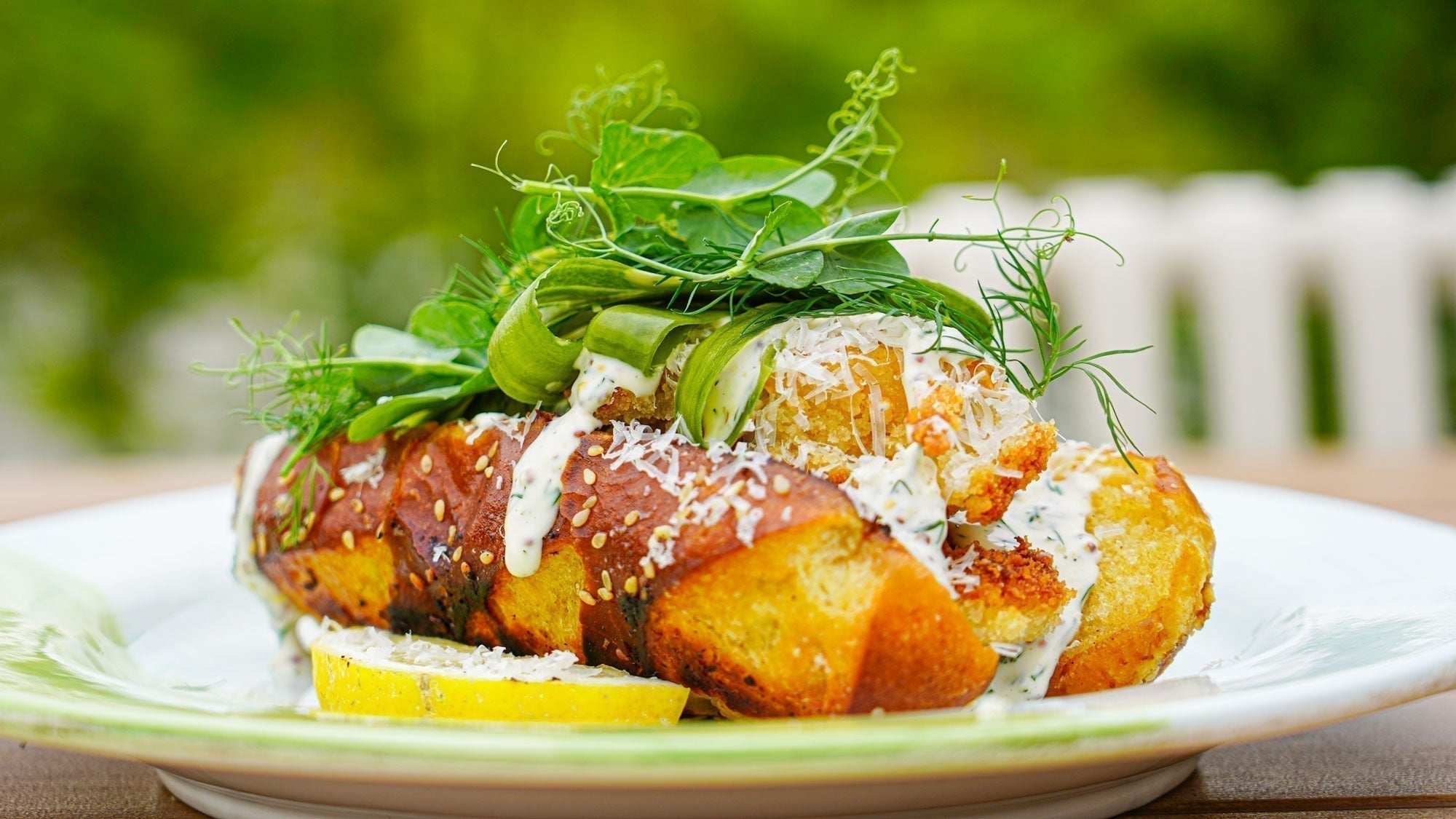 Krokante vishotdog met Parmezaanse kaas, dillemayo & snel ingelegde komkommer