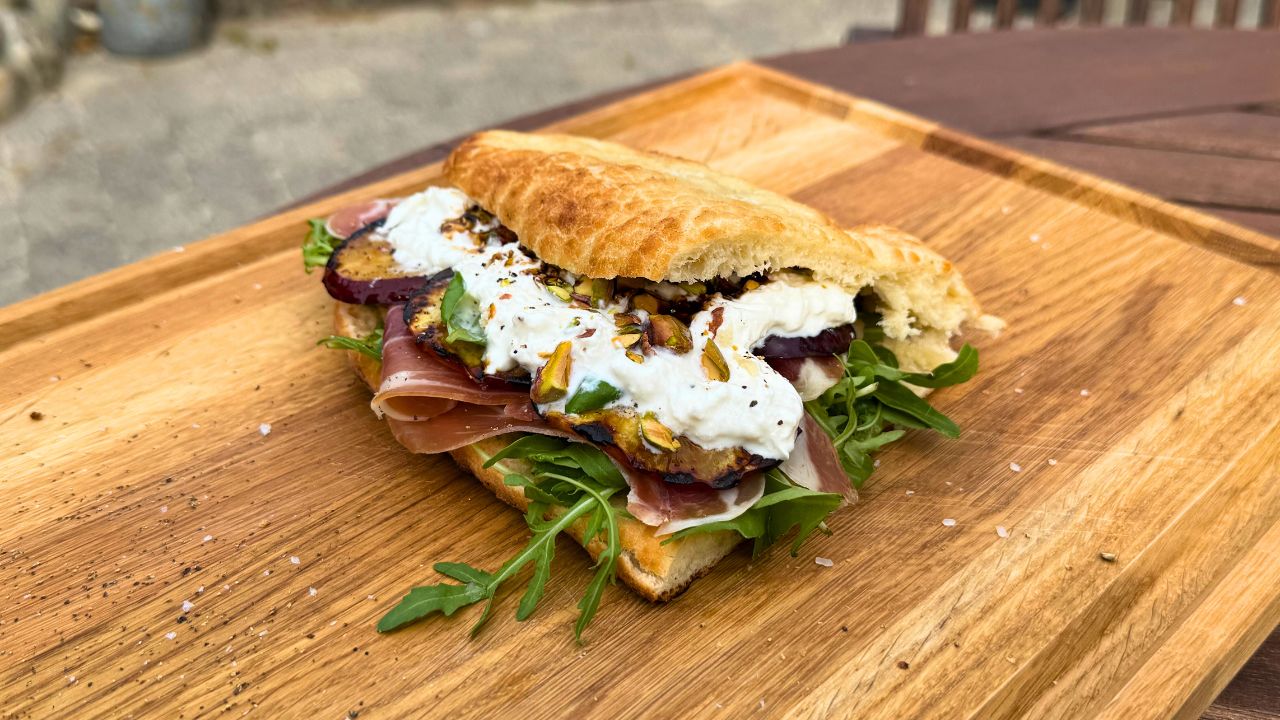 Focaccia met gegrilde nectarines, serranoham, burrata en pistachenoten