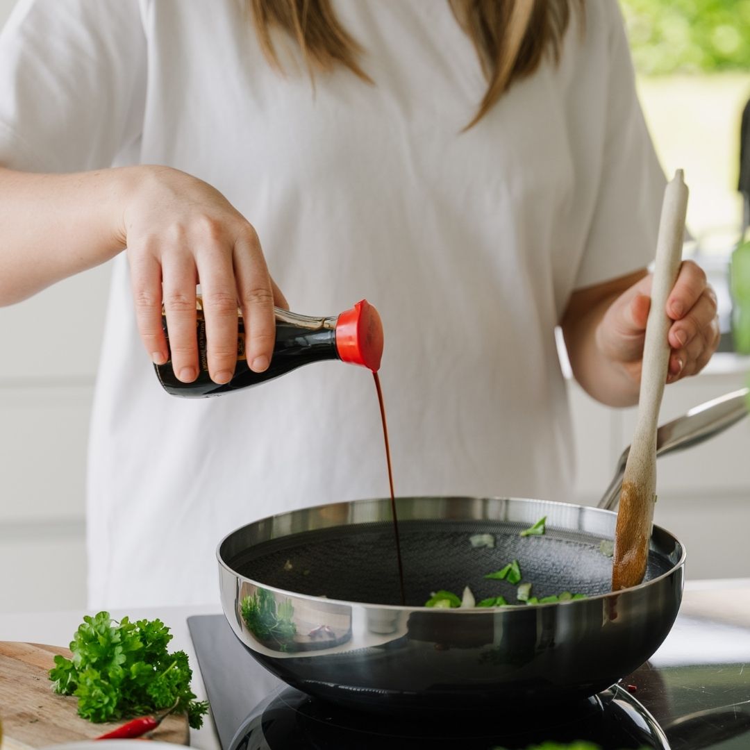 Wokpan met sojasaus op het fornuis