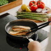 Zalm in koekenpan op het fornuis