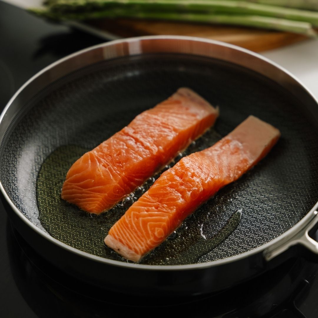 Zalm in een koekenpan op het fornuis 